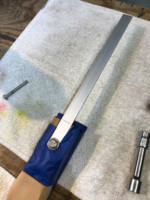 Bolted on aluminum flat stock is the handle for holding neck while painting.