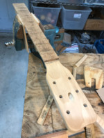The headstock and fingerboard during sanding process.